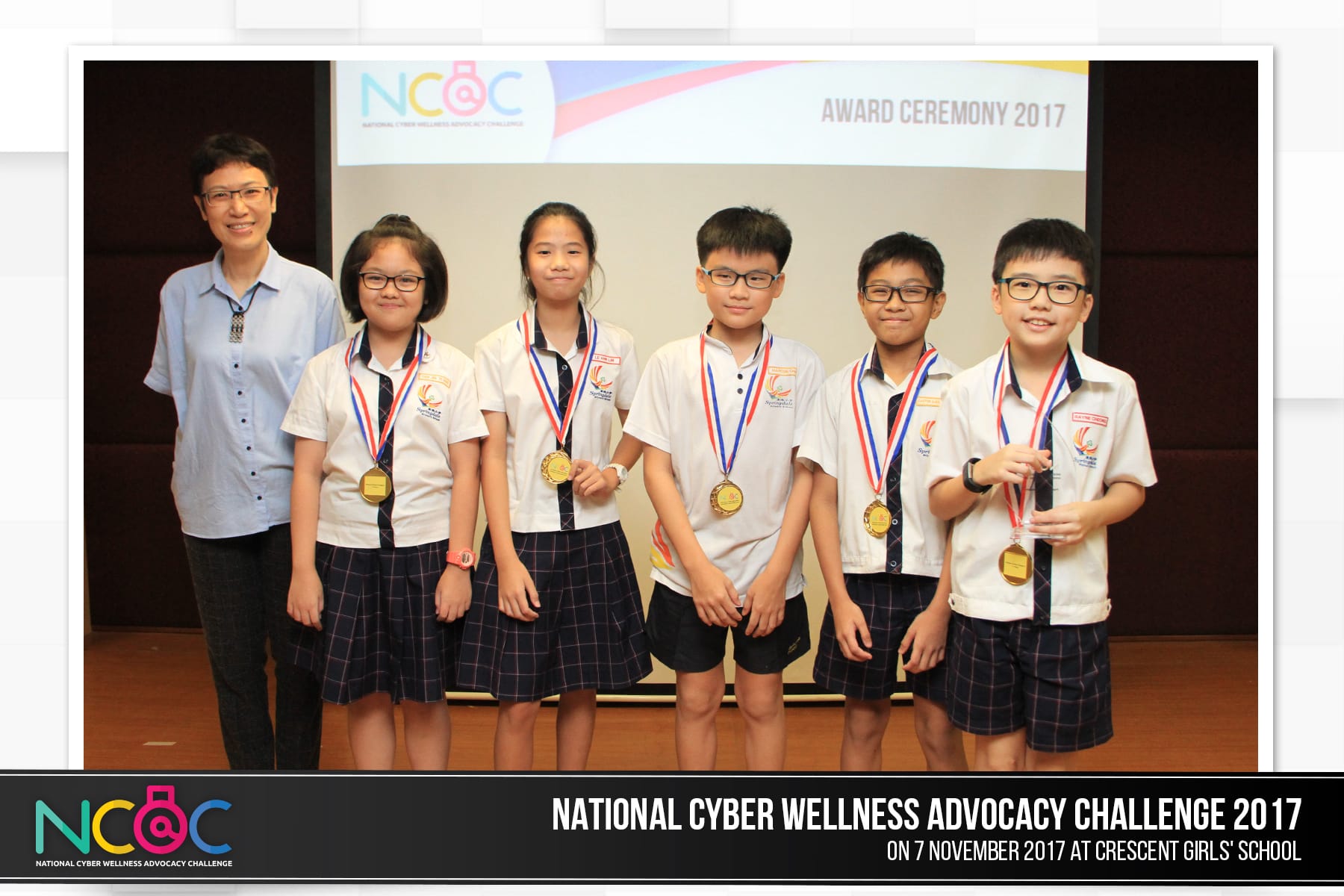 Five students wearing gold medals stand with an adult at the NCAC Award Ceremony 2017.